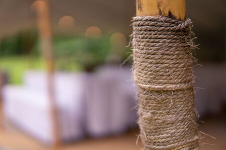 Image of modern wedding decoration with flowers in brown bottels and blurry lights in the background in a tentの写真素材