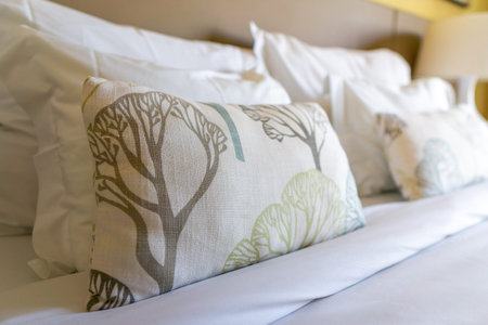 Image of several pillows on bed with white blanket, decorationの写真素材