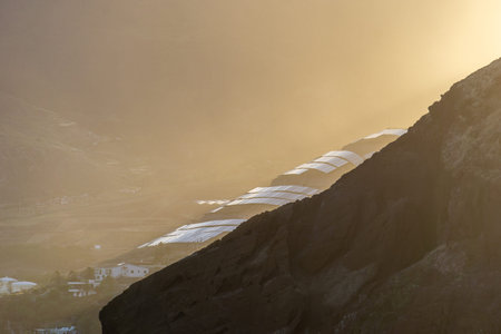 Image of solar panels on a hill with sunset sunlight breaking through clouds creating epic...
