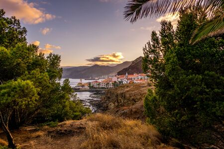 Hidden view on village at the coastline during sunset, Madeiraの写真素材