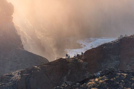 Group of people enjoy the rough breaking of the waves during sunset on a cliff with epic sunset tones, Madeiraの写真素材