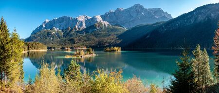 Panorama Image of Eibsee during autumn with the Zudspitze in the background and water reflectionsの写真素材
