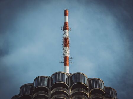 View from bottom to top of a red and white painted radio antenna on a skyscraper, Augsburg, Germanyの写真素材