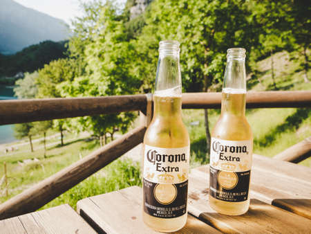 Milan, Italy - March 15, 2020: Two bottles of Corona Extra on a wooden table in the sun.のeditorial素材