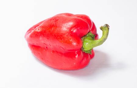 Red pepper on white background with green tail. Side viewの写真素材
