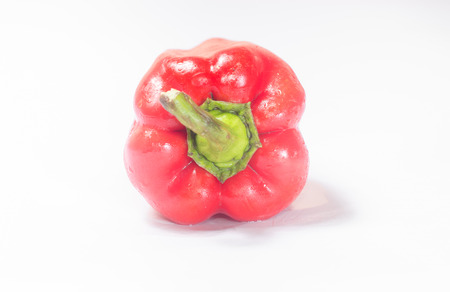 Red pepper on white background with green tail.  Front viewの写真素材
