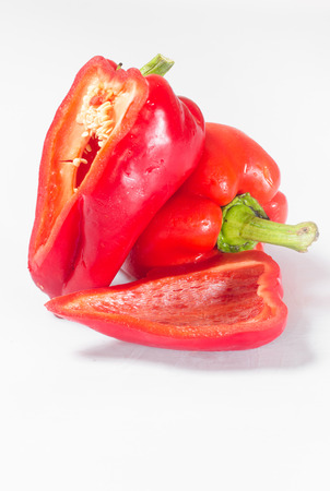 A whole pepper and pepper slices on a white background with a green sprigの写真素材