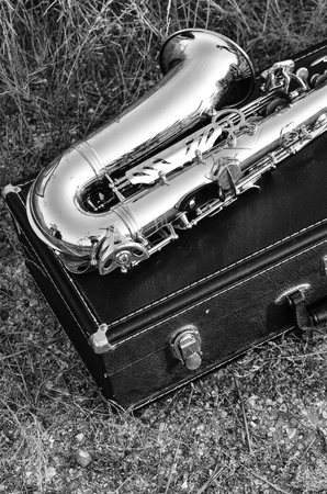 The saxophone lies on the black box on the sunset. Black-and-white photographの写真素材