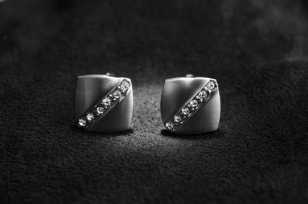 Silver cufflinks with rhinestone on the black matter at the center, of the cufflinks catches the...