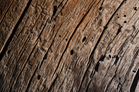 The texture is an old gray wooden board with cracks and whipped holes. Horizontal photo, wallpaperの写真素材