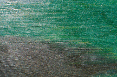 The cardboard is covered with a watercolor paint of green and black colors. Long strokes horizontallyの写真素材