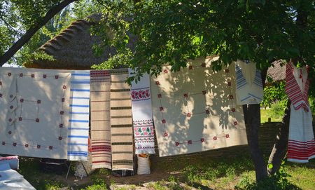 Ukrainian embroidered linen and white towels and shirts hang among the treesの写真素材