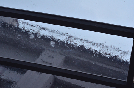 Strong rain pours on a glass roof during daylight hoursの写真素材