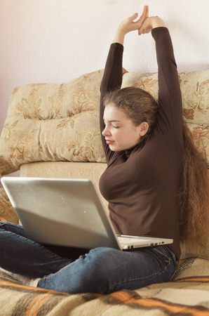 Young Cute Female Student Doing Homework in Bed. College Student Doing Homework in Bed at Home, Young Woman Preparing School Test in Bedroom. Education Concept.の写真素材