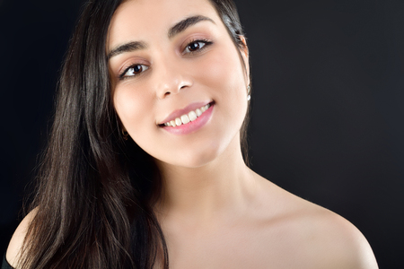 Portrait of a beautiful girl on a black background which is naked on the shouldersの写真素材