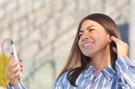 Beautiful girl on a Sunny spring day listening to music and enjoying lifeの写真素材
