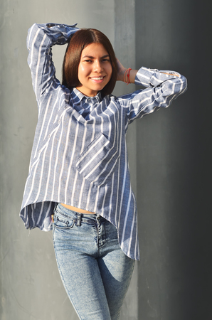 Young asian girl fashion posing near black the wall and is enjoing the sunny dayの写真素材