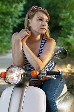 Portrait of young woman on scooter. Outdoor on streetの写真素材