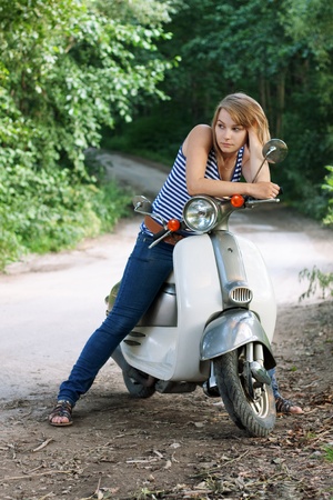 Portrait of young woman on scooter. Outdoor on streetの写真素材