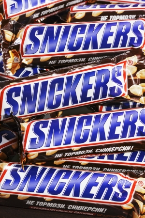 Closeup of many Snickers Snickers candy chocolat bars made by Mars Inc.のeditorial素材
