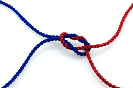 Red and blue ropes tied together by surgical knot, reflection on white background の写真素材