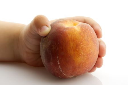 KidÂs hand holding single ripe peach の写真素材