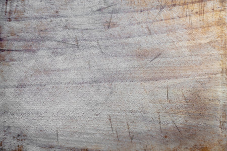 Old scratched wooden cutting board texture background.
