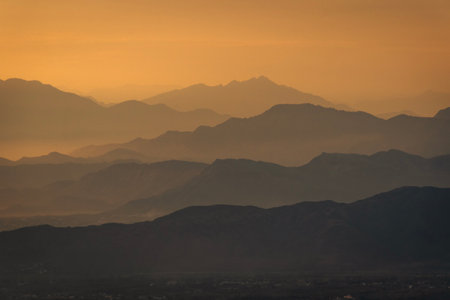 Golden hour hues paint the mountain ranges, casting a serene glow over the landscape.の写真素材