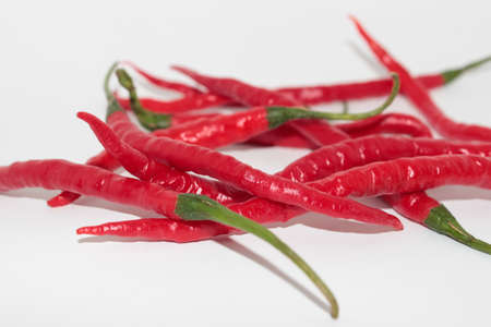 Fresh curly red chilies on  whiteの写真素材