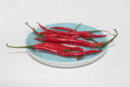 Fresh curly red chilies on  whiteの写真素材