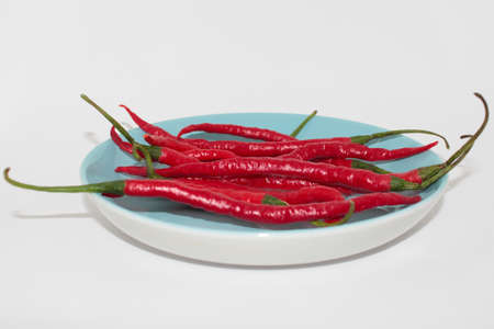 Fresh curly red chilies on  whiteの写真素材