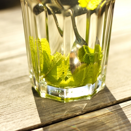 Glass of hot tea with a fresh peppermint and lemon, wooden backgroundの写真素材