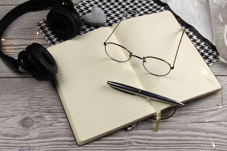 Leather handbag, clean blank notepad, pen, glasses, watch on a wooden background, top view. Free space for text.の写真素材