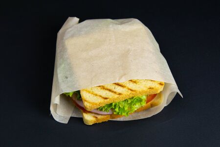 Sandwich of several slices of white bread on a wooden board. The filling of the sandwich consists of cheese and hamの写真素材
