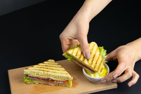 Close up on pair of young girls hands removing a healthy wholesome wholemeal bread ham sandwichの写真素材