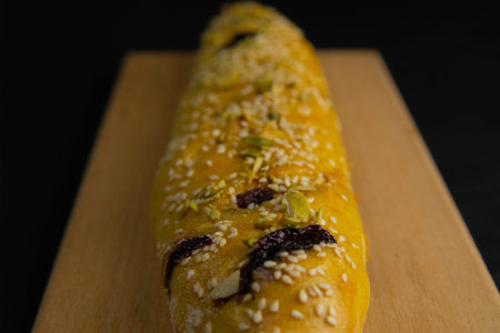 Freshly prepared puff pastry with cherry and sesame seeds close-up in a black background. Details...