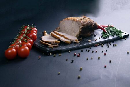 Grilled pork steaks and rosemary with hot paper and sauce on black stone background with allspice in different colors. Top view with copy spaceの写真素材