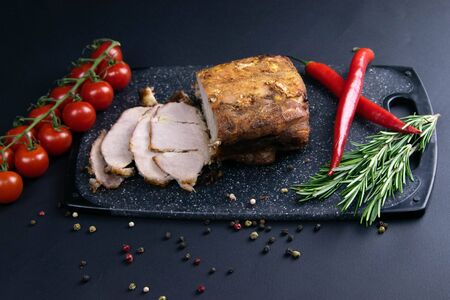 Grilled pork steaks and rosemary with hot paper and sauce on black stone background with allspice in different colors. Top view with copy spaceの写真素材