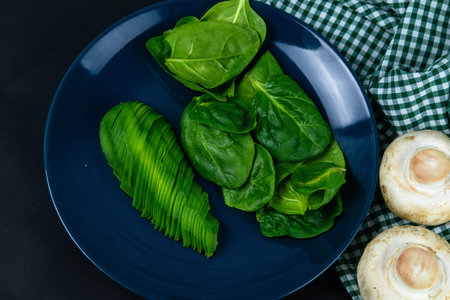 Bulgarian pepper, mushrooms and sliced avocado on a blue plate, in addition to the composition of...