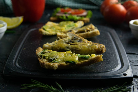 Grey cutting board sandwiches with mushrooms and cheese and sandwiches with avocado and cheese,...