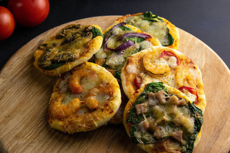 Small mini pizza. Set of different mini pizzas. Ppizza on wooden board : with shrimp, with...