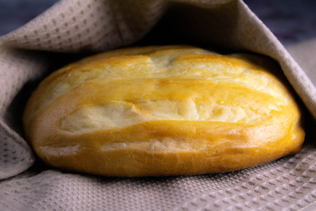 Homemade Bread on white towel under natural sun light. Front views