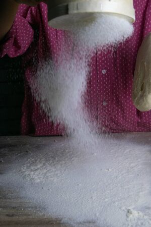 It's full of flour, women's hands sprinkle the table with flour. Preparing for dough and baking. Front viewsの写真素材