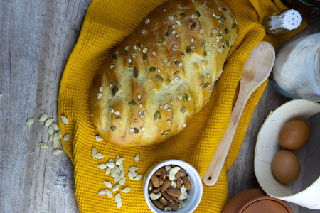 Concept shot of breads on the wood table, with egg, flour, seeds and nuts. Front views