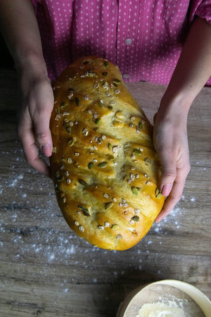 Closeup of fresh rustsic bread in a woman's hand. Top views