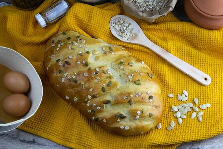 Concept shot of breads on the wood table, with egg, flour, seeds and nuts. Front viewsの写真素材