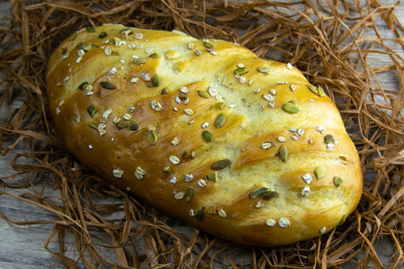 Dietary bread with seeds and nuts stands on a bunch of decorative dry grass. Top views