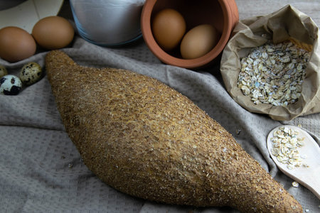 Crisp oatmeal bread wrapped with eggs and oatmeal in the background. Top views