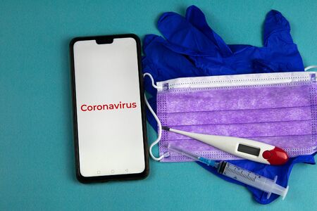 Coronavirus 2019-nCoV. Corona virus outbreaking. Epidemic virus Respiratory Syndrome. Mask, syringe, thermometer, tablets and gloves, With a phone that says coronavirusの写真素材