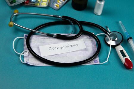 Coronavirus 2019-nCoV. Corona virus outbreaking. Epidemic virus Respiratory Syndrome. Phonendoscope, Mask, syringe, tablets and gloves with a piece of paper written on coronavirusの写真素材